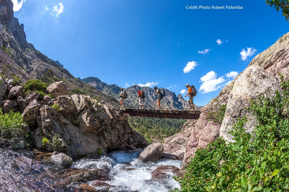 Randonneurs traversant un pont dans les montagnes corses