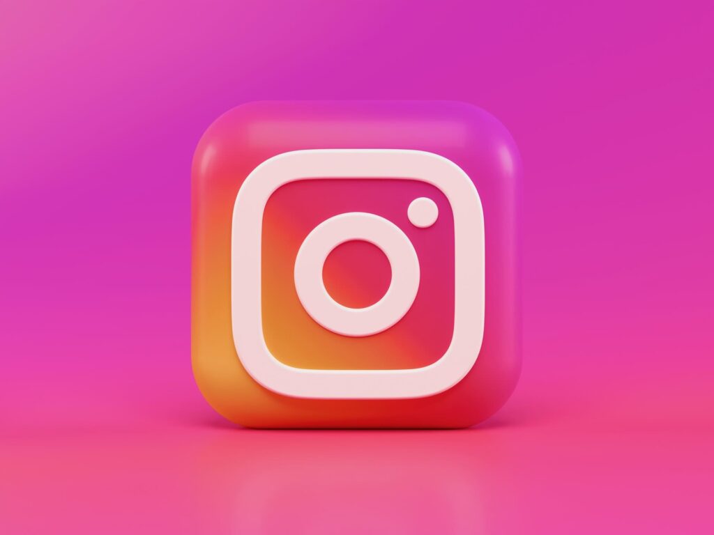 Logo d'Instagram en 3D avec un fond rose et violet.